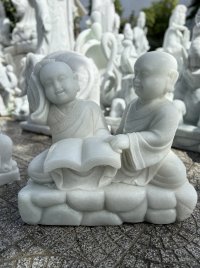 Hai tượng chú tiểu ngồi đọc sách đá nguyên khối.